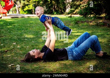 Schwester verbringt an einem warmen Herbstnachmittag Zeit mit ihrem kleinen Bruder, der an einem Down-Syndrom leidet, in einem Stadtpark; Leduc, Alberta, Kanada Stockfoto