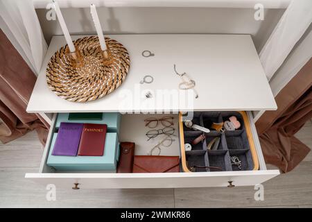 Offene Schublade mit Juwelen und Pässen im unordentlichen Wohnzimmer nach dem Raub Stockfoto