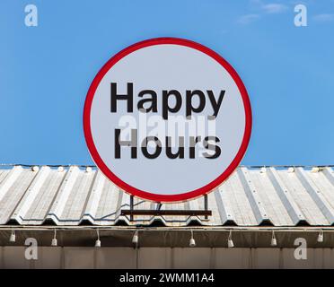 Auf dem Dach befindet sich eine kreisförmige Werbetafel mit den Happy Hours. Stockfoto