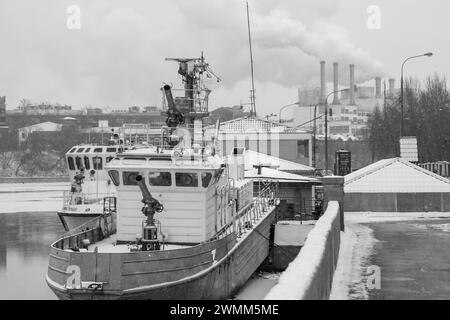 Festgefahrenes Feuer und Rettungsboot auf einem Winterfluss. Schwarz-weiß. Stockfoto