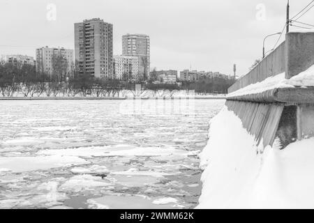 Winterblick auf den Moskauer Fluss. Eisbruch nach dem Durchlaufen eines Eisbrechers und Schneetreiben auf der Damampfbrüstung nach starkem Schneefall. Schwarz und Stockfoto