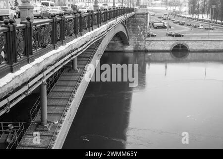 Eis auf dem winterlichen Moskauer Fluss unter der Bolschoi-Kamenny-Brücke am Kreml-Damm. Schwarz-weiß. Stockfoto