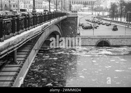 Eisdriften auf dem winterlichen Moskauer Fluss unter der Bolschoi-Kamenny-Brücke auf dem Kreml-Damm. Schwarz-weiß. Stockfoto