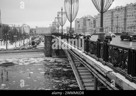 Eisdriften auf dem winterlichen Moskauer Fluss unter der Bolschoy-Kamenny-Brücke mit Blick auf den Bolotnaja-Platz. Schwarz-weiß. Stockfoto