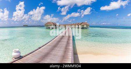 Wunderschöne maledivische Wasservilla in blauer Lagune und blauem Himmel. Panorama-Sommerlandschaft, Lagune mit entspannendem idyllischem, wolkenblauem Himmel Stockfoto