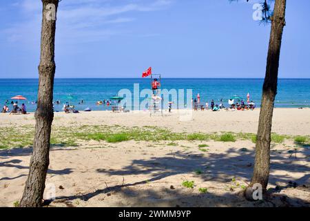 Yangyang County, Südkorea - 30. Juli 2019: Ein Rettungsschwimmer wacht von ihrem Stand am Bukbun Village Beach aus, eingerahmt von zwei Kiefern mit Paras Stockfoto