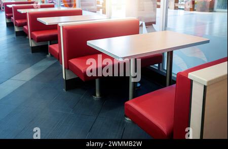 Leeres Fastfood-Restaurant mit roten Stühlen und Tisch in einer Reihe Stockfoto