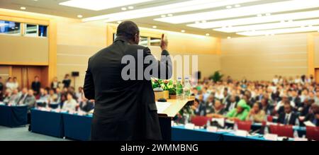 Geschäftsmann hält eine Rede vor einem großen Publikum Stockfoto