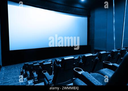 Dunkles Kino mit Leinwand und Stühlen Stockfoto