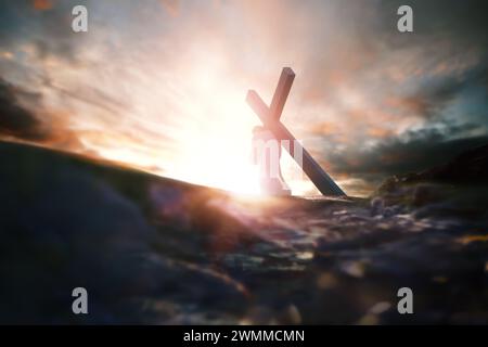 Calvary Golgotha Hill roter Himmel, helles Licht und Jesus, der das Kreuz trägt, symbolisiert Schmerz und Prüfungen, Tod und Auferstehung, Passionswoche Hintergrund Stockfoto