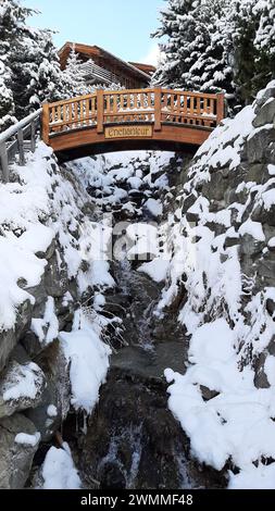 Brücke über den Alpenfluss hoch in den Bergen an einem sonnigen Tag mit Schnee auf dem Boden. Idyllischer Schweizer alpen Porträt Hintergrund. Verbier, Schweiz Stockfoto