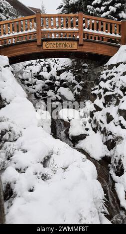 Wunderschöne Holzbrücke über einen Alpenbach, der im Winter in den Schweizer Alpen verschneit ist (Verbier, Kanton Wallis, Schweiz) Stockfoto