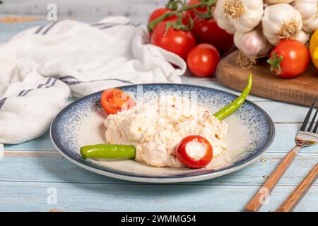 Olivenöl und scharfe Vorspeise. Vorspeisen. Atomic Dish mit scharfem Joghurt auf blauem Holzhintergrund. Lokaler Name Atom mezesi Stockfoto