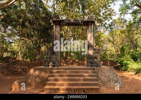 Old Goa, Indien - 19. Dezember 2022 : Ein einsamer Überrest aus dem Palast von Adil Shah aus dem 16. Jahrhundert, eine Steintür aus dem Palast, der abgerissen wurde Stockfoto