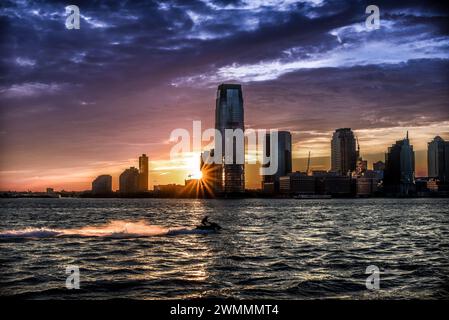 Ein traumhafter Sonnenuntergang über dem Wasser des Hudson River mit der Skyline von Jersey City am Horizont - Manhattan, New York City Stockfoto