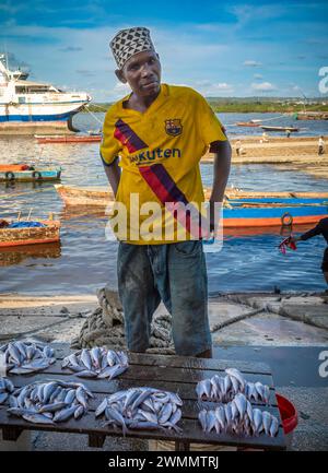 Ein Fischer verkauft Fisch am Ufer des Darajani Market oder auf dem Fischmarkt in Stone Town, Sansibar, Tansania. Stockfoto