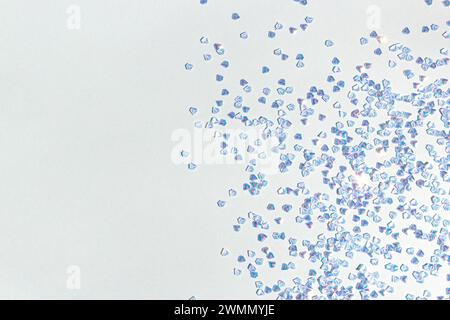 Silbernes Kristallkonfetti auf blauem Hintergrund. Glänzendes Konzept mit Platz für Text. Stockfoto