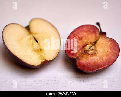 Ein frischer Apfel, der auf einem Tisch in zwei Hälften geschnitten wurde Stockfoto