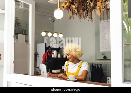 Eine junge birassische Frau genießt einen Kaffee in einem Café, mit Kopierraum Stockfoto