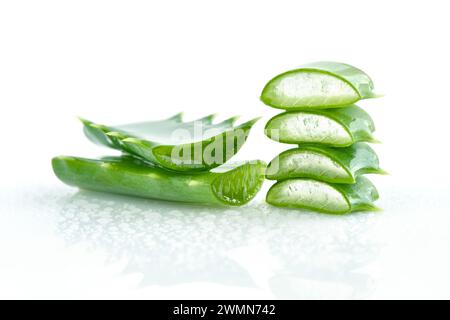 Frische Aloe Vera Blätter und Scheiben auf weißem Hintergrund mit Wassertröpfchen. Für Gesundheits- und Schönheitsprodukte. Stockfoto