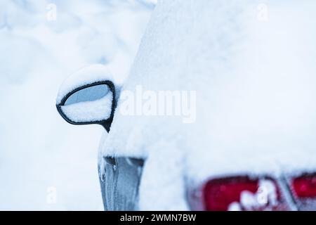 Ein Seitenspiegel von Autos ist von einer Decke aus frischem Schnee umgeben und spiegelt die kühle Winteratmosphäre in Schweden wider. Das Fahrzeug scheint stillstehend und beschichtet zu sein Stockfoto