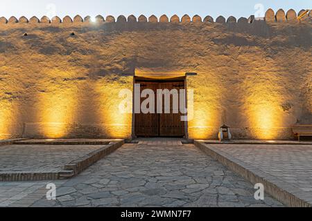 Geschnitzte Holztür in der Mauer einer mittelalterlichen Festung. Eine geschnitzte Holztür in der Mauer der mittelalterlichen Festung. Altstadt Ichan Kala. Chiwa, Uz Stockfoto