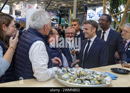 Paris, Frankreich. Februar 2024. Der französische Präsident Emmanuel Macron schmeckt Austern während der Eröffnung der 60. Internationalen Landwirtschaftsausstellung Stockfoto