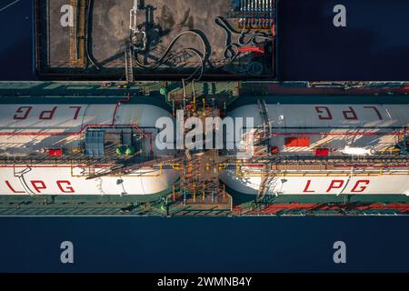 Luftaufnahme von oben nach unten auf Deck eines LPG-Tankschiffes mit Gasbehältern, die im Industriehafen vertäut sind. Stockfoto