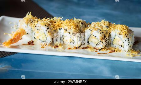EBI zehn Rollen, Nahansicht. Sushi-Set mit Garnelen in Tempura, Oshinko, garniert mit essbarer Blume und schwarzem Sesam, auf orientalischem Tablett, Teller bei re Stockfoto