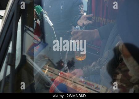 Riesiger Rush bei Benzinpumpen Amid Strike by Transporters 02.2024, Srinagar Kashmir, Indien : ein Mitarbeiter füllt die Flasche an einer Tankstelle in Srinagar. Massiver Ansturm auf Tankstellen in der ganzen Stadt Srinagar während landesweiter Streiks von Transportern gegen das Gesetz der Bharatiya Nyay Sanhita BNS, das indische Strafgesetzbuch aus der Kolonialzeit ersetzt. Fahrer, die durch fahrlässiges Fahren einen schweren Verkehrsunfall verursachen und weglaufen, ohne die Polizei oder einen Beamten der Verwaltung zu informieren, können mit einer Strafe von bis zu 10 Jahren oder einer Geldstrafe von 7 Rupien bestraft werden. Am 2. Januar 2024, Sri Stockfoto