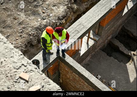 Nicht exklusiv: ZAPORIZHZHIA, UKRAINE - 26. FEBRUAR 2024 - Bauarbeiter legen Ziegelsteine am Sockel und an den Wänden des Erdgeschosses der beschädigten Sekte Stockfoto