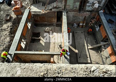 Nicht exklusiv: ZAPORIZHZHIA, UKRAINE - 26. FEBRUAR 2024 - Bauarbeiter legen Ziegelsteine am Sockel und an den Wänden des Erdgeschosses der beschädigten Sekte Stockfoto