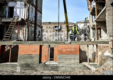 Nicht exklusiv: ZAPORIZHZHIA, UKRAINE - 26. FEBRUAR 2024 - Bauarbeiter sind an der Verlegung von Ziegeln am Sockel und an den Wänden des Erdbodens beteiligt Stockfoto