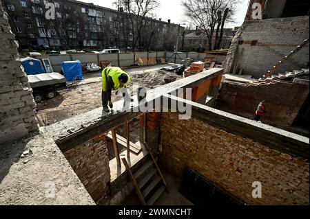 Nicht exklusiv: ZAPORIZHZHIA, UKRAINE - 26. FEBRUAR 2024 - Bauarbeiter sind an der Verlegung von Ziegeln am Sockel und an den Wänden des Erdbodens beteiligt Stockfoto