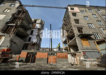 Nicht exklusiv: ZAPORIZHZHIA, UKRAINE - 26. FEBRUAR 2024 - Bauarbeiter legen Ziegelsteine am Sockel und an den Wänden des Erdgeschosses der beschädigten Sekte Stockfoto