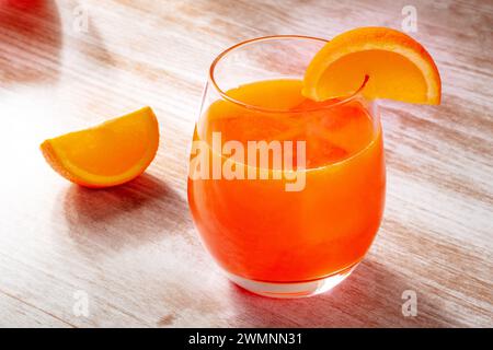 Orangengetränk auf hölzernem Hintergrund, frisch gepresster Saft mit Fruchtscheiben Stockfoto
