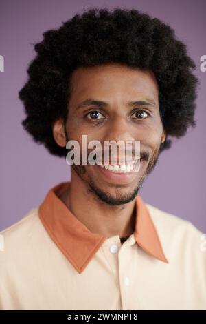 Kopfaufnahme eines lächelnden Schwarzen Mannes, der ein Poloshirt trägt Stockfoto
