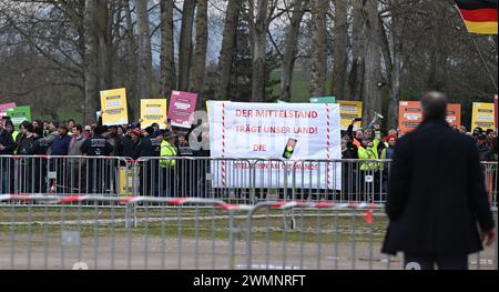 Freiburg, Deutschland. Februar 2024. Demonstranten stehen mit Spruchbändern vor Barrieren bei einer Festveranstaltung zum Spatenstich für den großen neuen Stadtteil Dietenbach in Freiburg. Quelle: Bernd Weißbrod/dpa/Alamy Live News Stockfoto