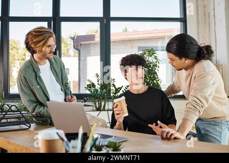 Junger Mann mit Kaffee, um mit seinen männlichen Kollegen über Startup-Projekt zu diskutieren, Zusammenarbeit Stockfoto