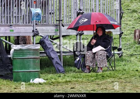 Crickhowell, Brecon Beacons, Wales, Großbritannien. August 2023. Das Green man Festival ist ein unabhängiges Musik-, Wissenschafts- und Kunstfestival, das jährlich Mitte August in den Brecon Beacons in Wales stattfindet. Green man hat sich zu einer Veranstaltung mit 25.000 Teilnehmern entwickelt, bei der überwiegend Live-Musik präsentiert wird. Im Bild: Festivalbesucher mit Regenschirm bei starkem Regen Credit: Nidpor/Alamy Live News Stockfoto