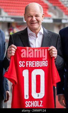 Freiburg, Deutschland. Februar 2024. Bundeskanzler Olaf Scholz (SPD) besucht das Europa-Park-Stadion des SC Freiburg und hält ein Trikot des SC Freiburg, das er als Geschenk erhalten hat, in der Hand. Quelle: Christoph Schmidt/dpa/Alamy Live News Stockfoto