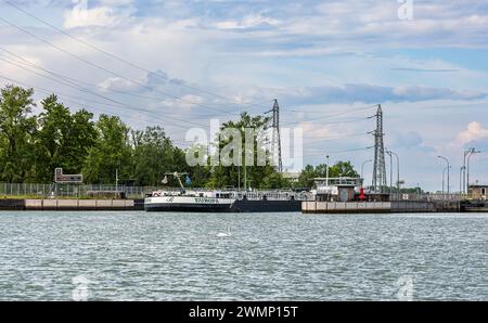 Das Rheinschiff Europa hat die Rheinschleuse Fessenheim passiert und fährt aus der Schleusenanlage hinaus, weiter auf dem Oberrhein in Richtung Basel. Stockfoto