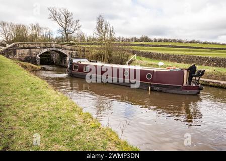 Schmalbootbetreiber wartet, während sein Ungeheuer die Schleusentore am Leeds & Liverpool Kanal bei Gargrave besucht. Stockfoto