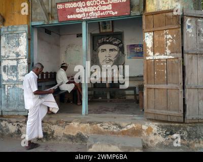 Indien, kerala, Kochi: Indische Männer lesen die Zeitung in einem öffentlichen Büro der Kommunistischen Partei Keralas mit dem Bild von Che Gevara Stockfoto
