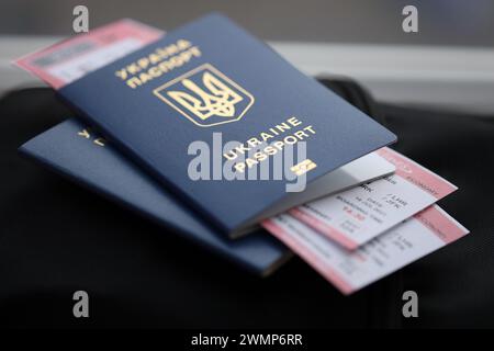 Zwei ukrainische biometrische Pässe mit Flugtickets auf schwarzem touristischem Rucksack Nahaufnahme Stockfoto