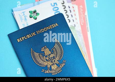 Blauer Indonesien Pass mit Geld und Flugtickets auf blauem Hintergrund Nahaufnahme. Tourismus und Reisekonzept Stockfoto