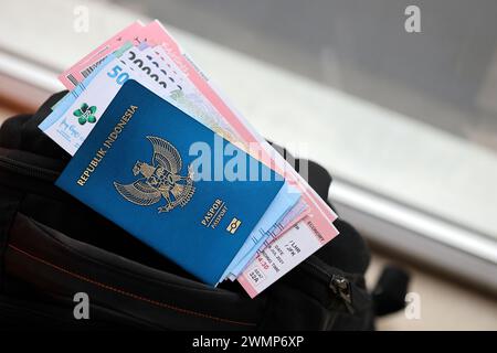 Blue Republic Indonesien Pass mit Geld und Flugtickets auf touristischen Rucksack Nahaufnahme. Tourismus und Reisekonzept Stockfoto