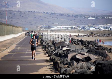 Menschen laufen, joggen, wandern und Radfahren entlang des Flughafenweges playa de matagorda Lanzarote, Kanarische Inseln, spanien Stockfoto