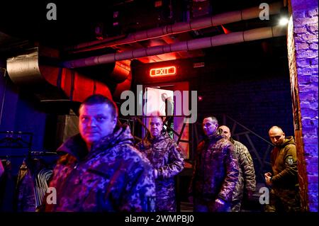 ZAPORIZHZHIA, UKRAINE - 26, 2024 - Soldaten nehmen an der Eröffnung der Fotoausstellung "an der Frontlinie des Lebens" Teil, die Fotos zeigt, die während der Kampfeinsätze des Militärs aufgenommen wurden, organisiert von Soldaten der 116. Separaten Mechanisierten Brigade, im Orbita-Kulturpalast in Zaporischzhia, Südostukraine. Stockfoto