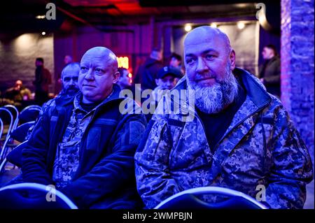 ZAPORIZHZHIA, UKRAINE - 26, 2024 - Soldaten nehmen an der Eröffnung der Fotoausstellung "an der Frontlinie des Lebens" Teil, die Fotos zeigt, die während der Kampfeinsätze des Militärs aufgenommen wurden, organisiert von Soldaten der 116. Separaten Mechanisierten Brigade, im Orbita-Kulturpalast in Zaporischzhia, Südostukraine. Stockfoto